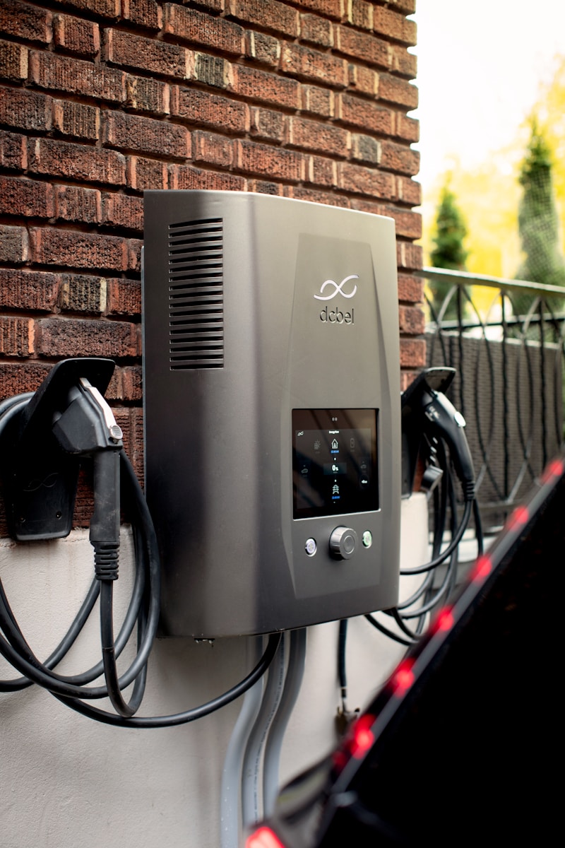 Electric car charger mounted on brick wall outdoors