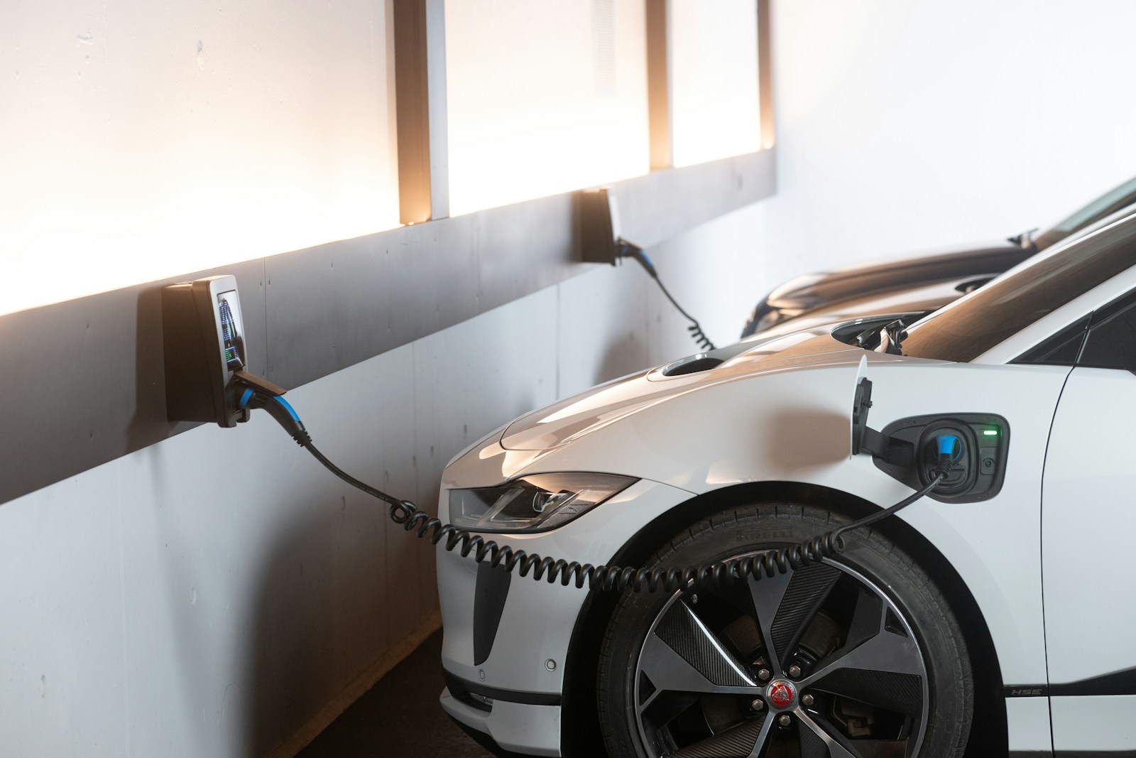 White electric car charging at a station