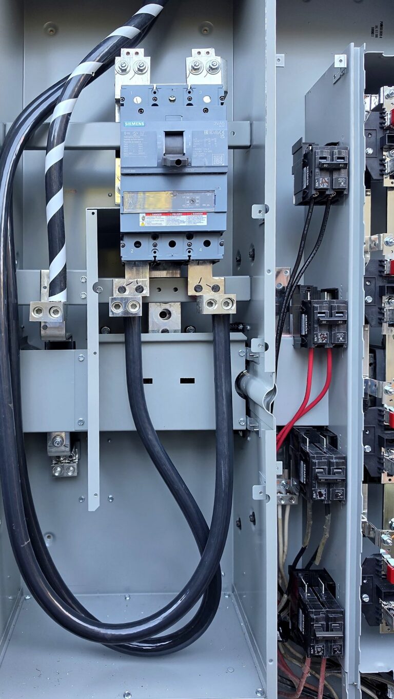 Main breaker and service conductors inside a commercial switchboard installed by Volta Electric