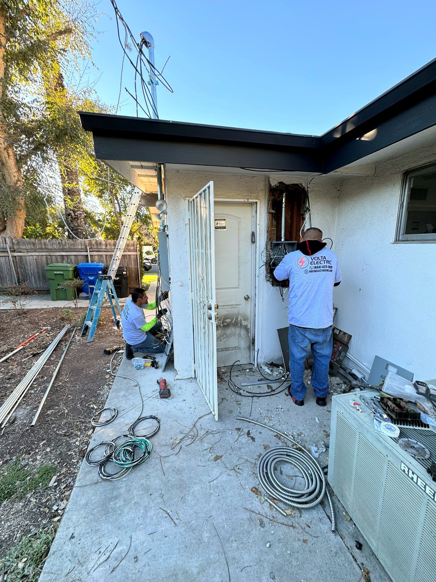 Volta Electric crew installing a new electrical panel on an exterior wall