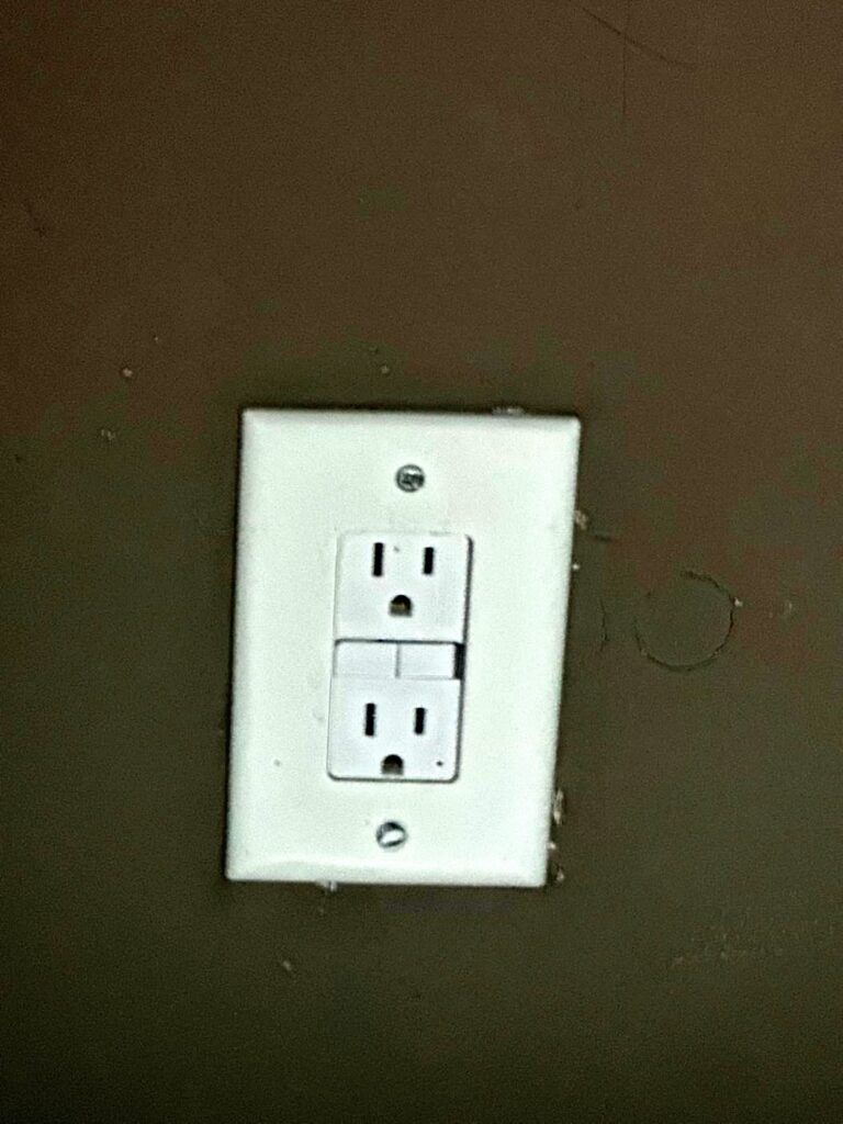 New GFCI outlet installed by Volta Electric on a dark accent wall