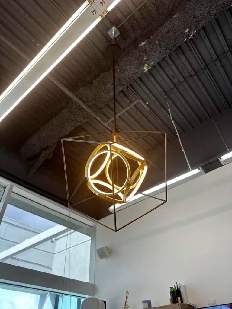 Geometric pendant in an office with exposed wood ceiling