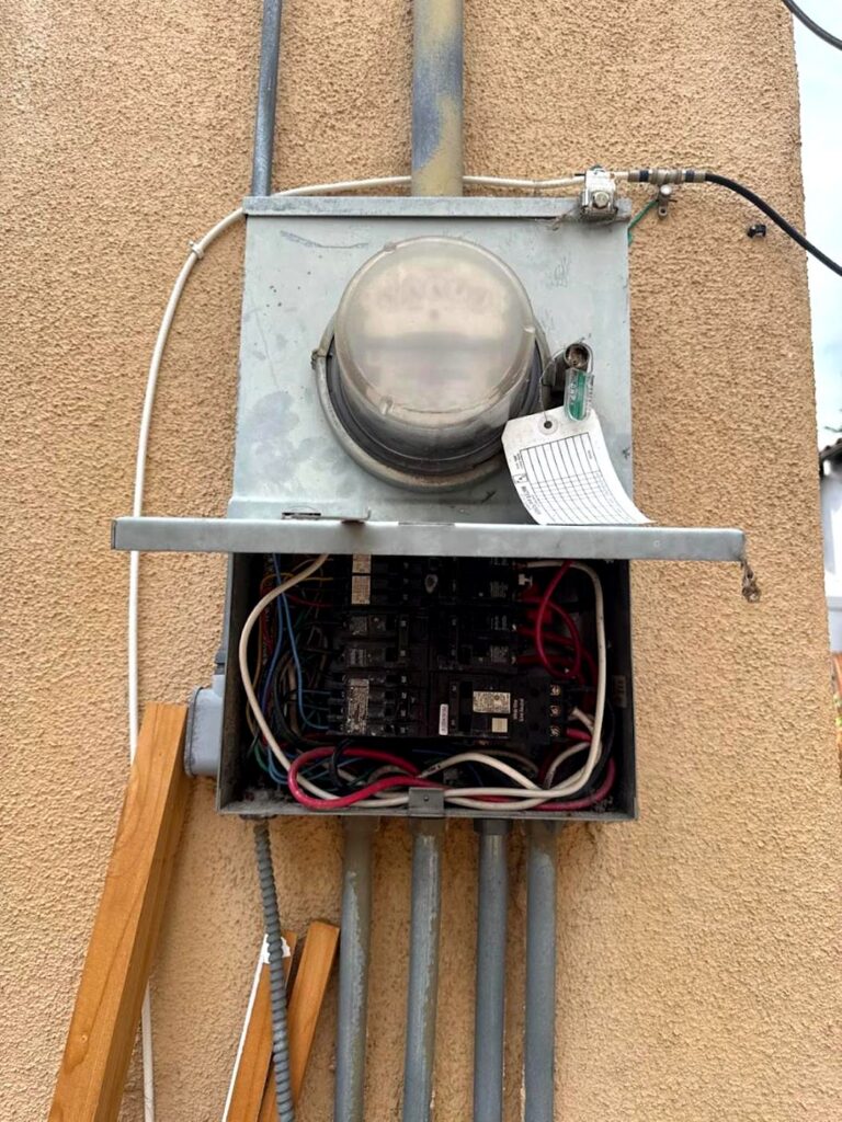 Old exterior meter and panel photographed by Volta Electric before replacement