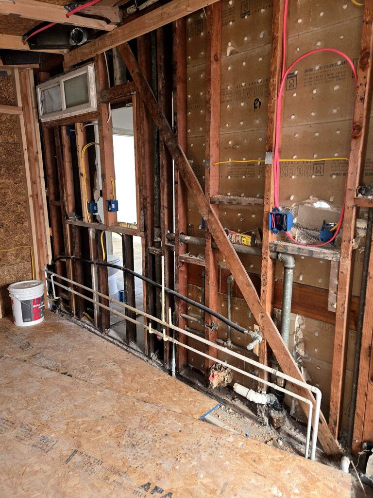 Open wall with new wiring run through the studs during a Volta rewire