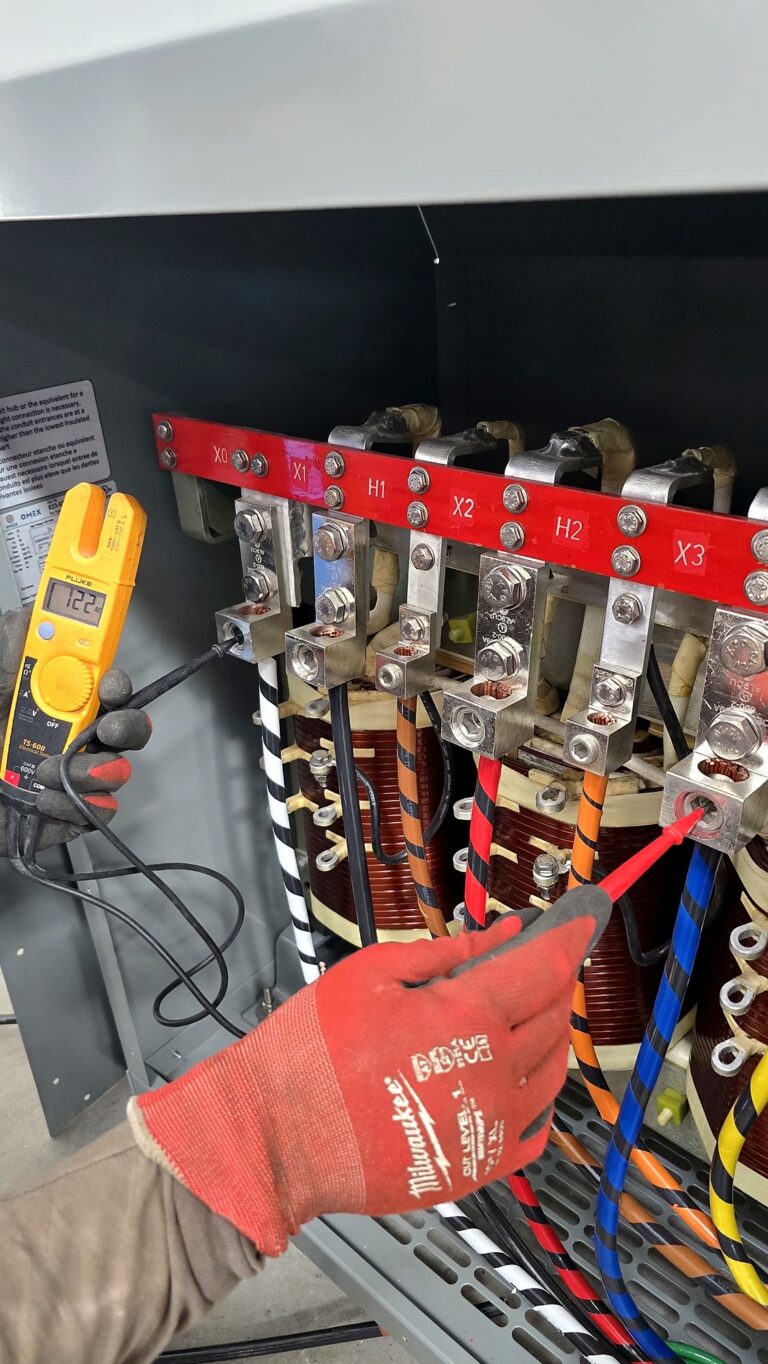 Volta Electric electrician testing the terminals of a dry-type transformer