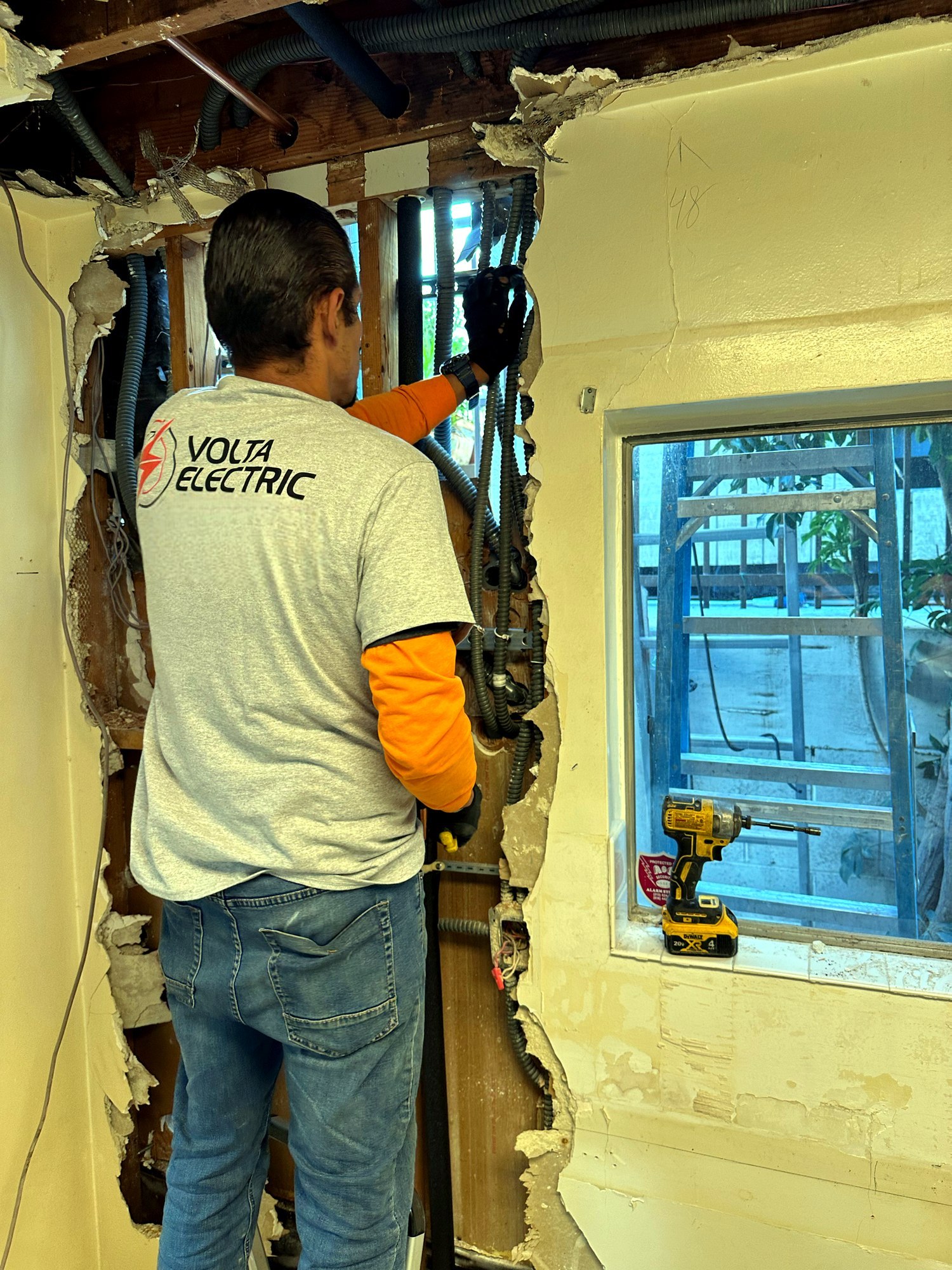 Volta Electric technician running wiring during an interior rough-in