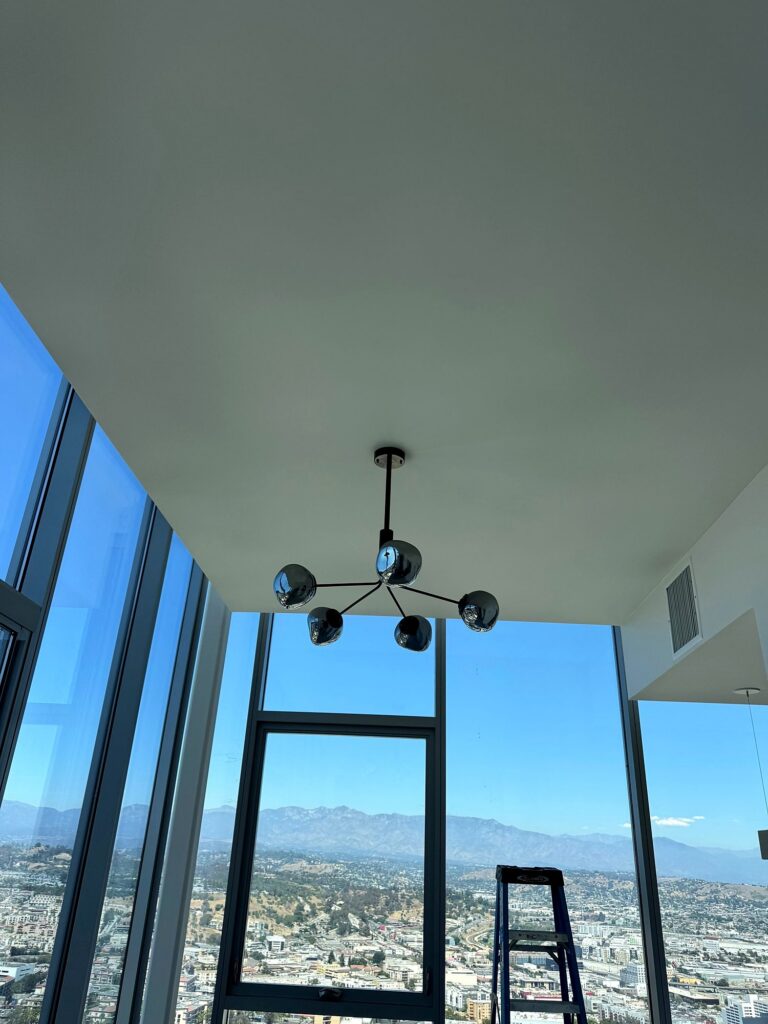 Modern chandelier in a high-rise condo with a city view