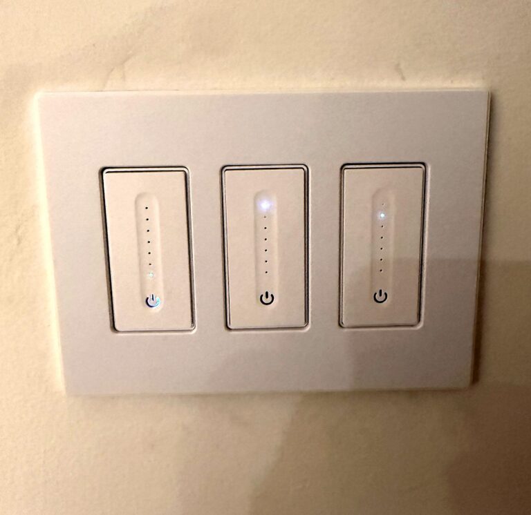 Three smart dimmer switches on a wall plate