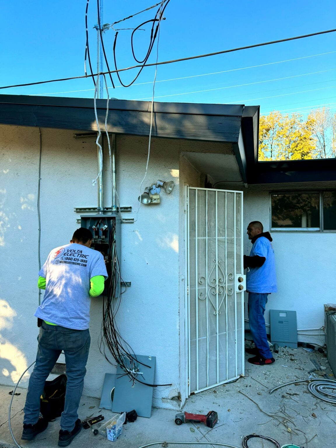 Two Volta Electric technicians working together on a panel installation in Los Angeles